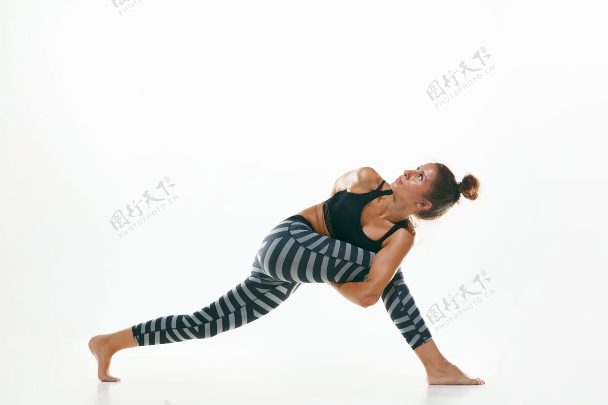 灵活运动型年轻女性 在白色工作室背景下做瑜伽练习适合灵活的女性模特练习健康生活方式的概念 身体和心理发展之间的自然平衡运动员课程教练