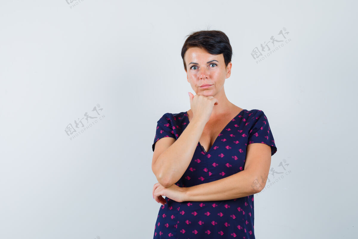 休闲黑发女人站在思考的姿势在红色和紫色图案的裙子 并期待着重点前视图站着室内漂亮