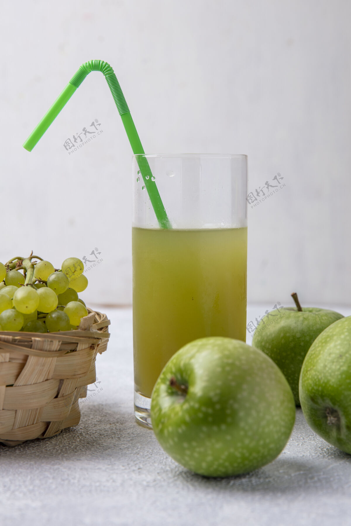 绿色前视图绿色葡萄在一个篮子与梨绿色苹果和苹果汁绿色吸管在一个白色的背景玻璃梨植物水果