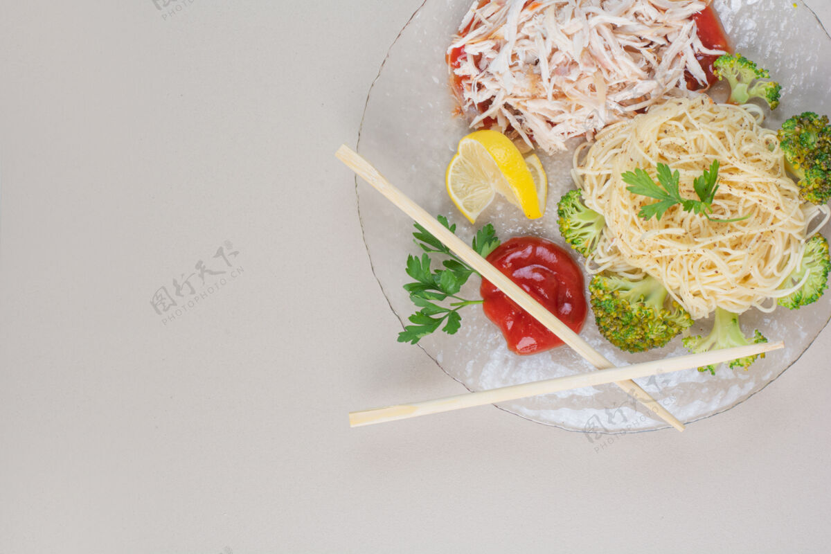 自制在白色表面放上意大利面 鸡肉和蔬菜的玻璃盘子西兰花美味意大利面