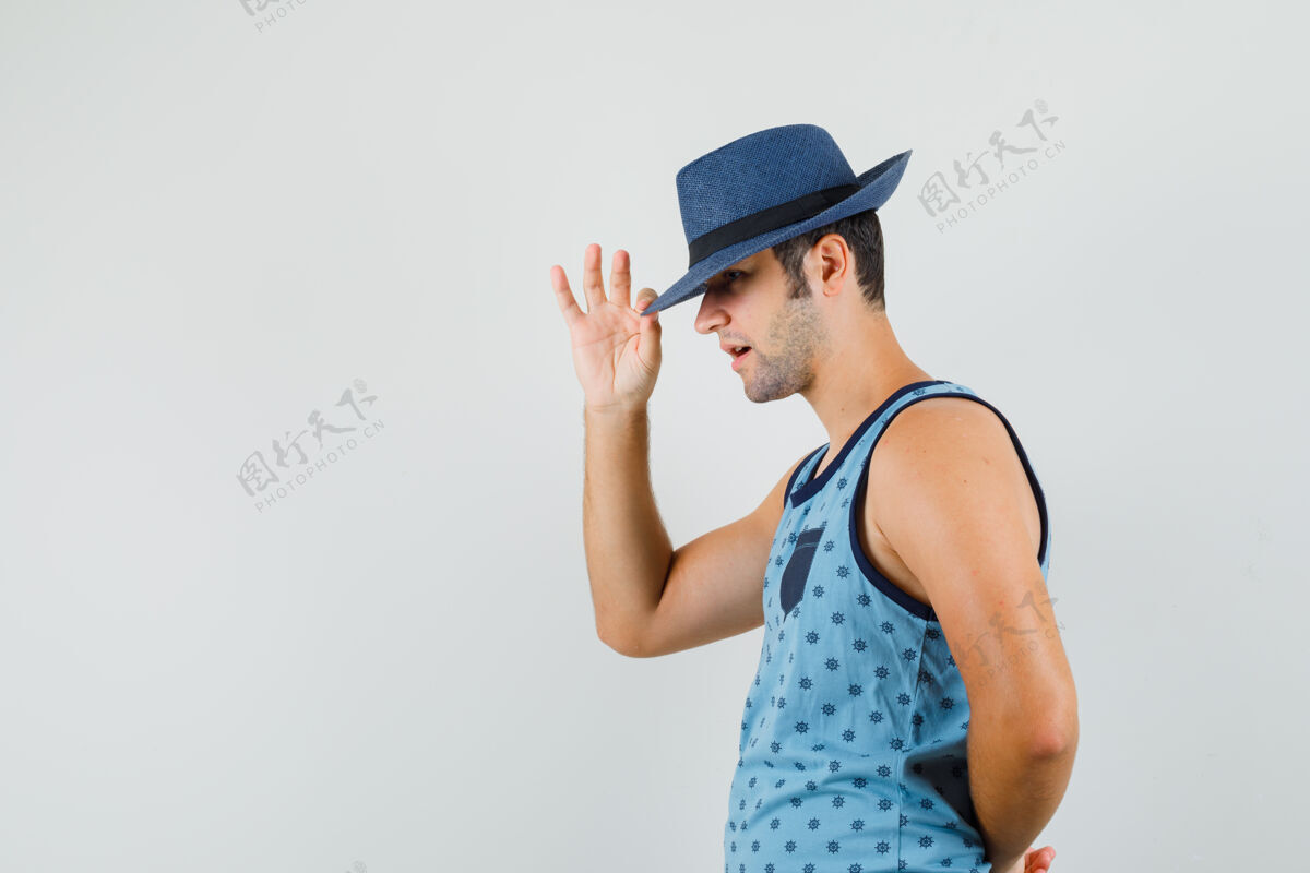 朋友穿蓝色单品的年轻人摘下帽子遮住眼睛 看上去很优雅成人人单身