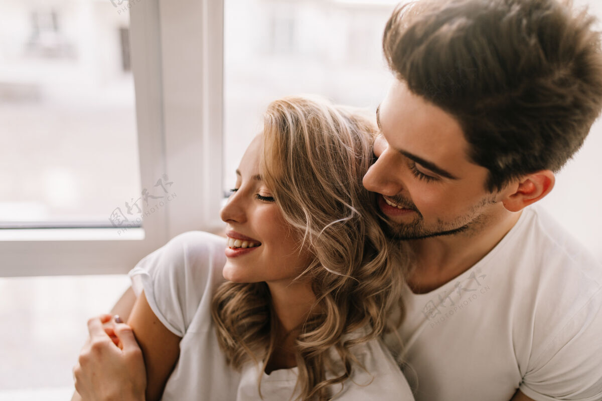 关系幸福的男人在早上拥抱女友放松的金发女人和男朋友的室内画像男朋友男人休闲