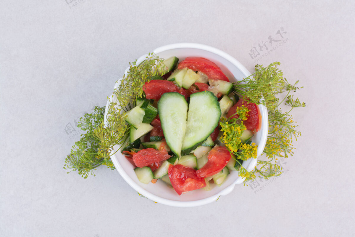 有光泽把黄瓜和西红柿切成片放在白碗里 配上绿色蔬菜黄瓜新鲜切