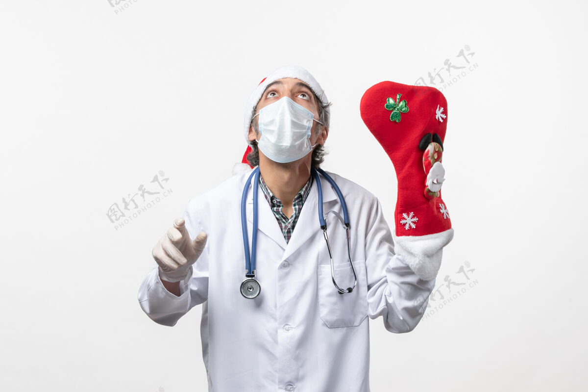 圣诞节正面图白色墙壁上戴着大红袜子的男医生-圣诞节医院视图男医生
