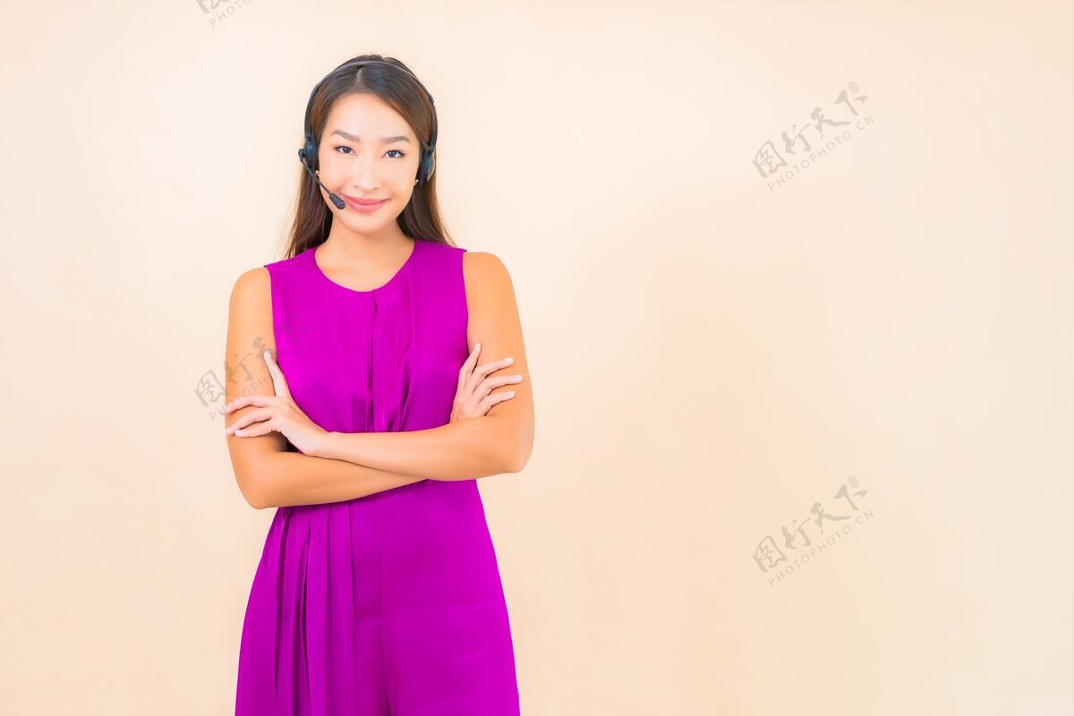 亚洲人在彩色背景上为呼叫中心客户描绘美丽的亚洲年轻女子和耳机工人接线员电话营销