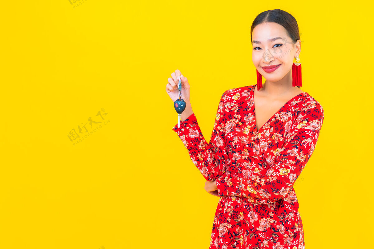 显示在黄色的墙上画一幅美丽的亚洲年轻女子拿着车钥匙亚洲人女人人