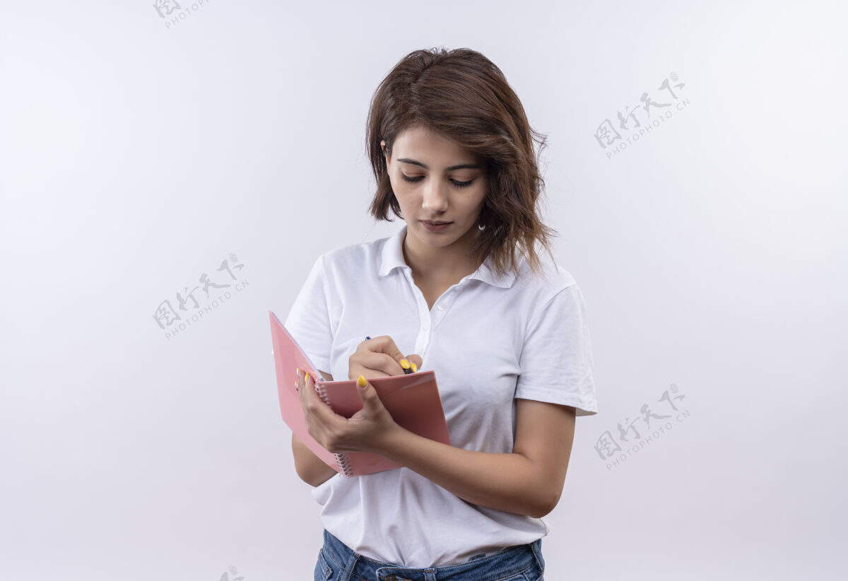 衬衫一个留着短发的小女孩 穿着白色马球衫 手里拿着笔记本和钢笔 表情严肃笔记本脸短裤