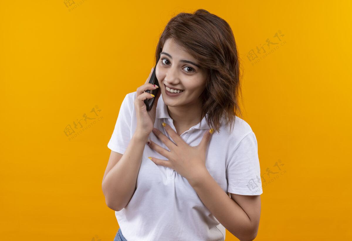 衬衫穿着白色马球衫 留着短发的年轻女孩 一边打电话 一边心情愉快女孩穿手机