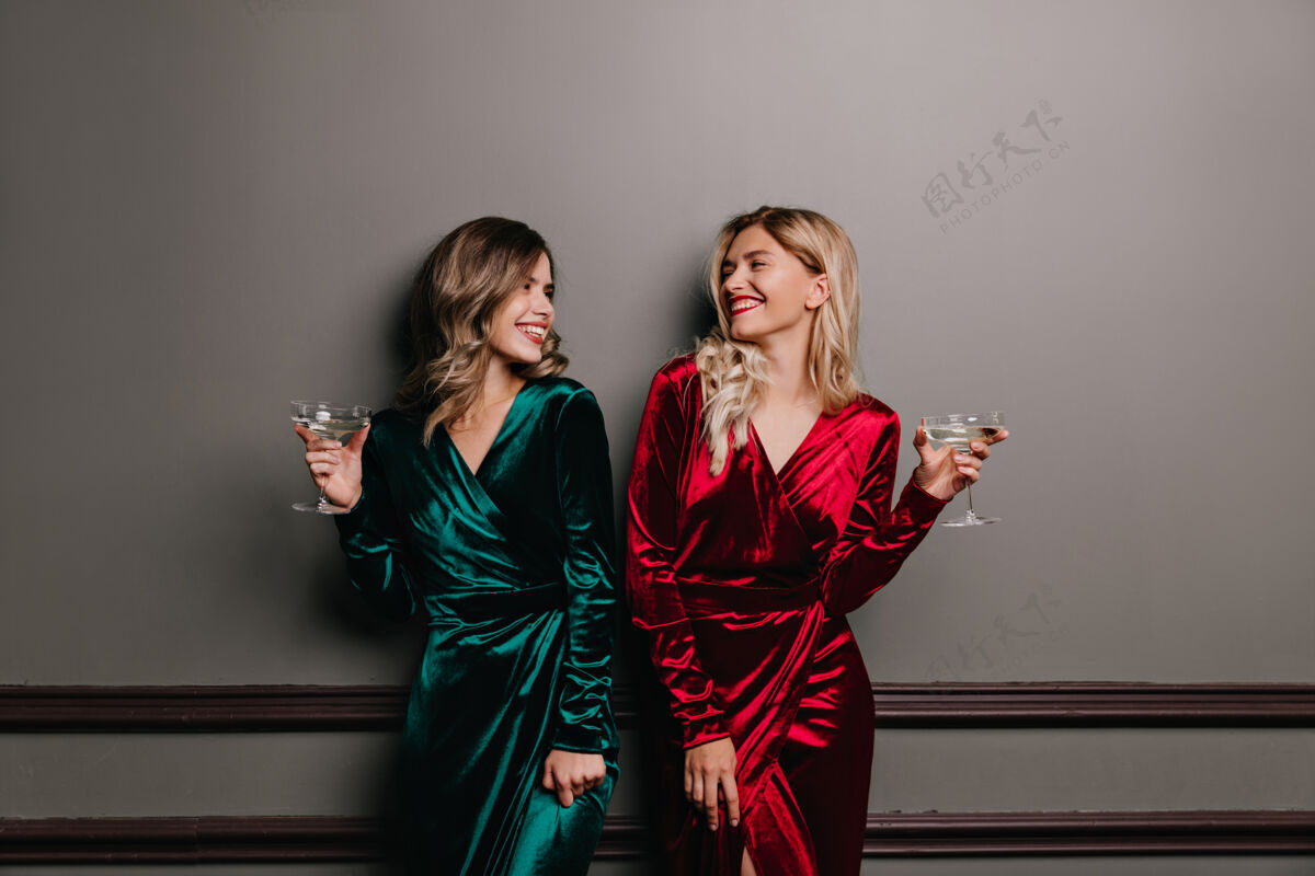 女人穿着考究的姑娘们一边喝酒一边互相对视 朋友们一边谈笑风生礼服葡萄酒享受