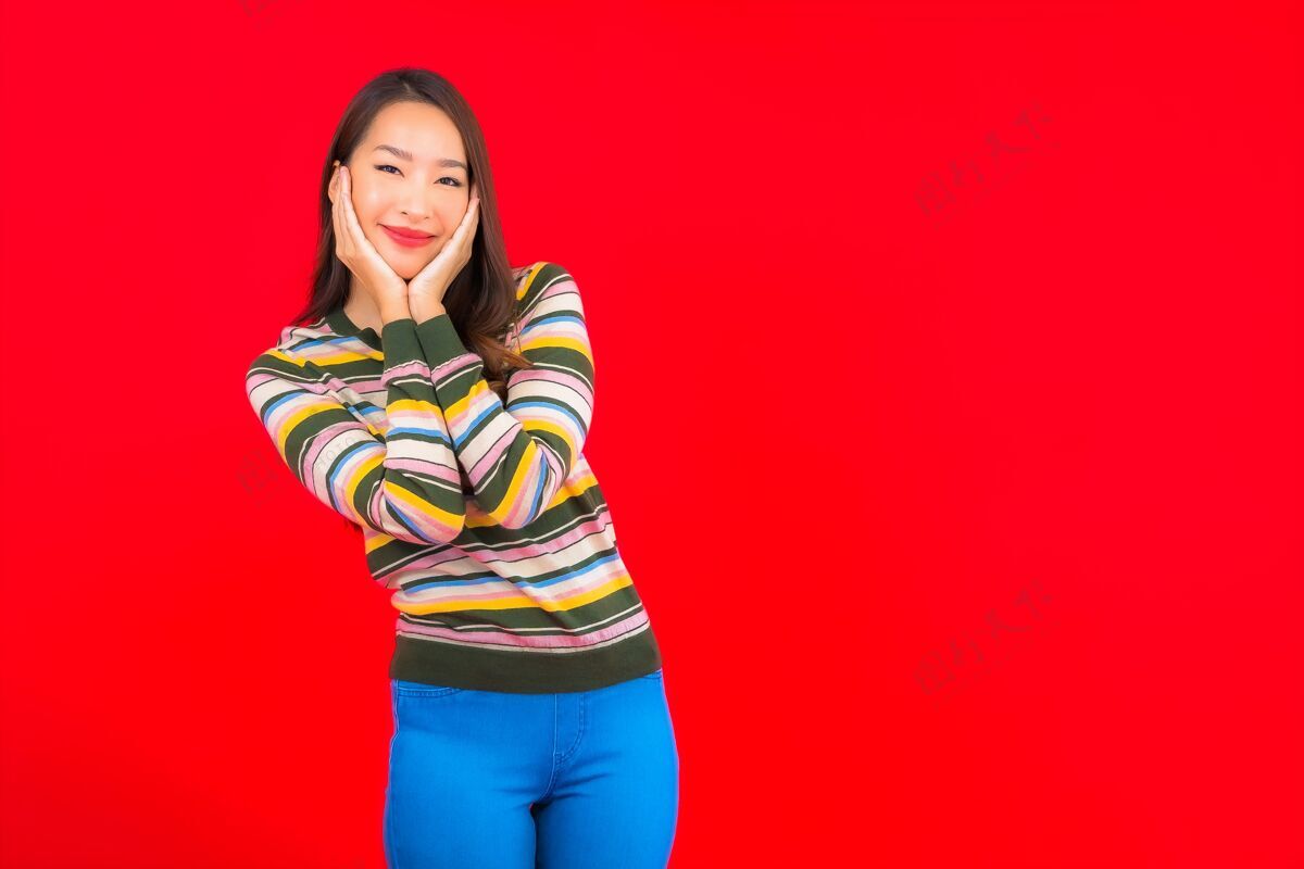 服饰美丽的亚洲年轻女子在红色隔离墙上微笑长相快乐微笑