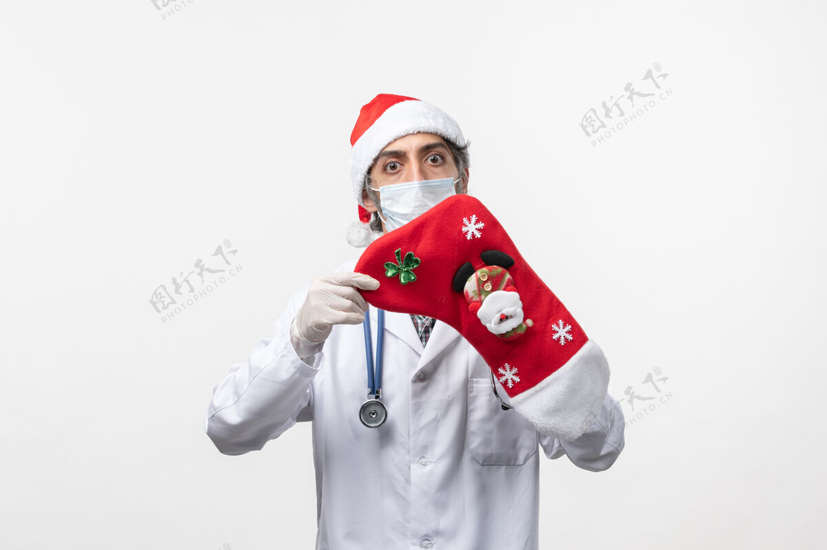 桌子正面图白色办公桌上戴着大红袜子的男医生-圣诞节视图袜子病毒