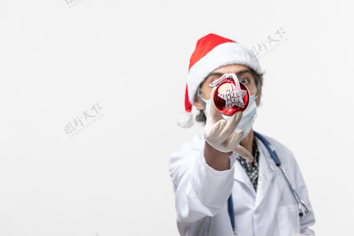 成人男医生手持新年树玩具健康病毒冠状病毒圣诞节微笑