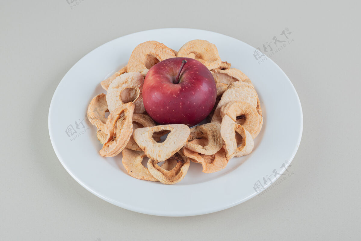 甜一个白色的盘子里装满了干苹果和一个完整的苹果收获甜点薯条