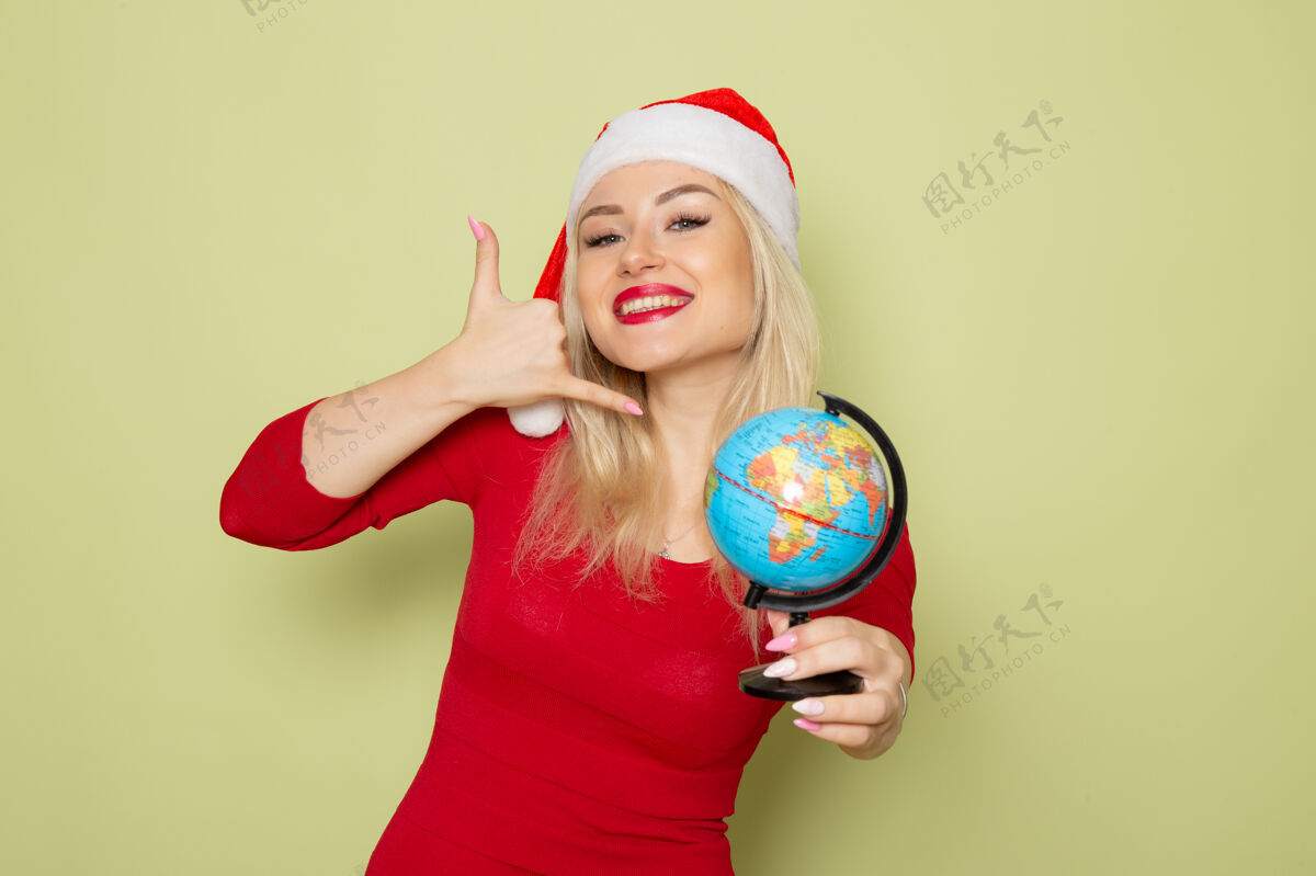 小前景靓女抱着小地球仪在绿墙上过节圣诞雪新年情感色彩漂亮的女人情感成人
