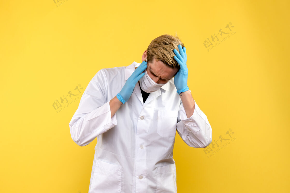 人正面图黄色背景上头痛的男医生大流行健康冠状病毒大流行衣服外套