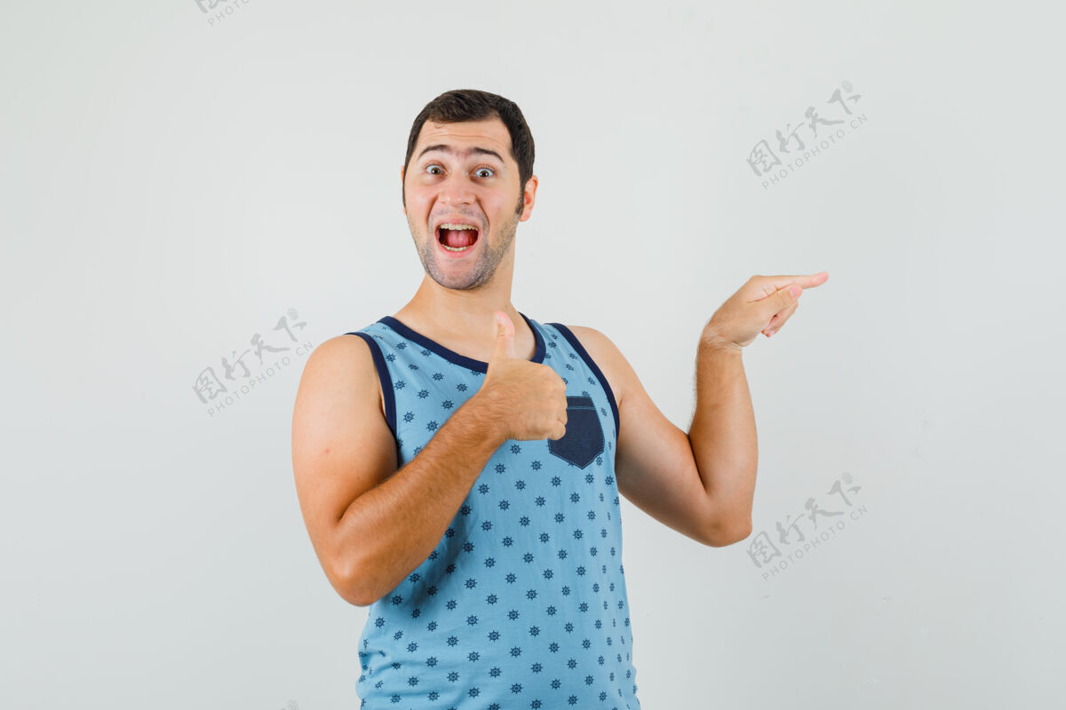 男性穿蓝色单品的年轻人指着旁边 竖起大拇指 看上去很高兴成功商人胡须