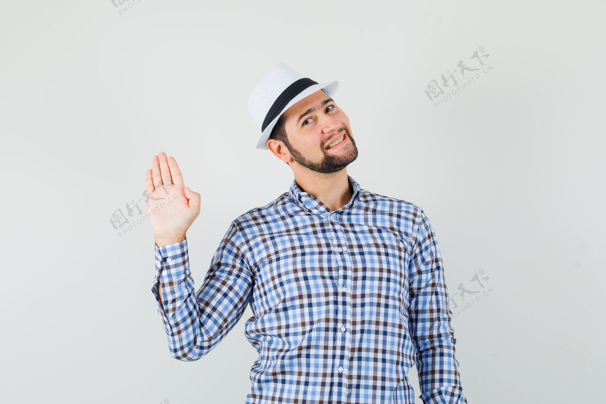虚拟穿着格子衬衫 戴着帽子 面带笑容的年轻男子挥手致意或告别正面图站立英俊衬衫