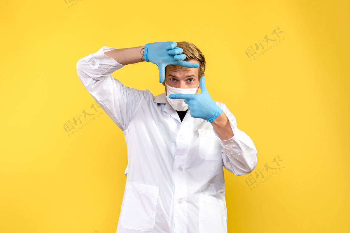 工作前视图照片中的男医生在黄色背景上摆姿势大流行性冠状病毒-健康病毒实验室专业医学