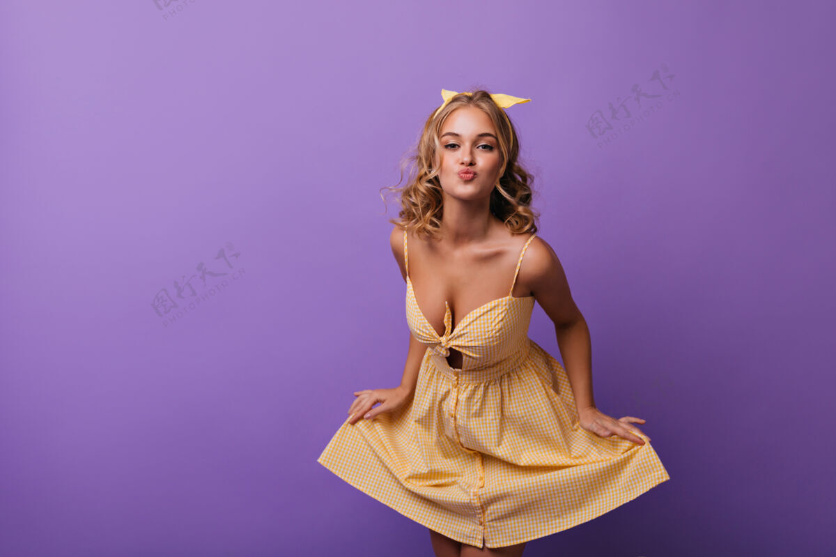 女性身材匀称的年轻女子 波浪式的发型表达着爱室内画像是一个皮肤黝黑 穿着黄色夏装的浪漫女孩模特欣喜若狂明亮