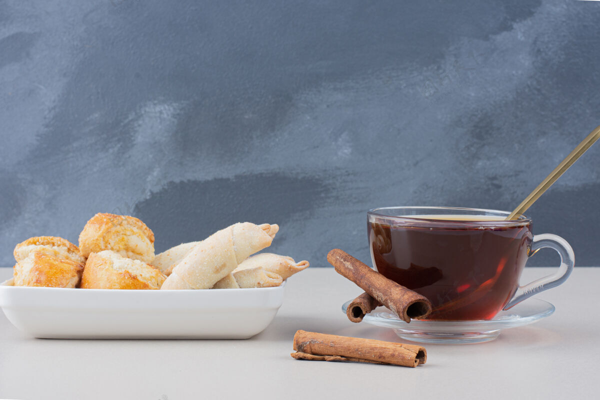 甜点一杯茶加肉桂和饼干放在白色的桌子上茶杯子美味