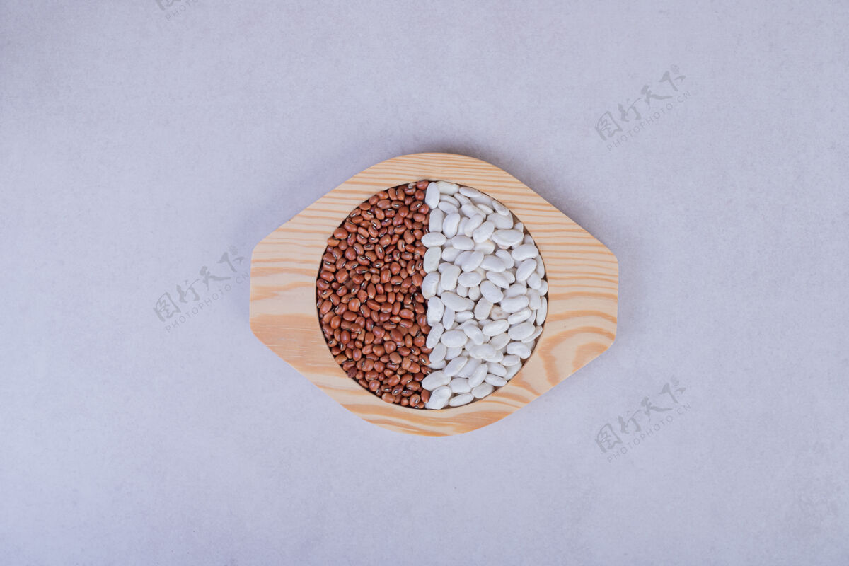 木材两种生豆子和豌豆放在木盘里豌豆蔬菜背景