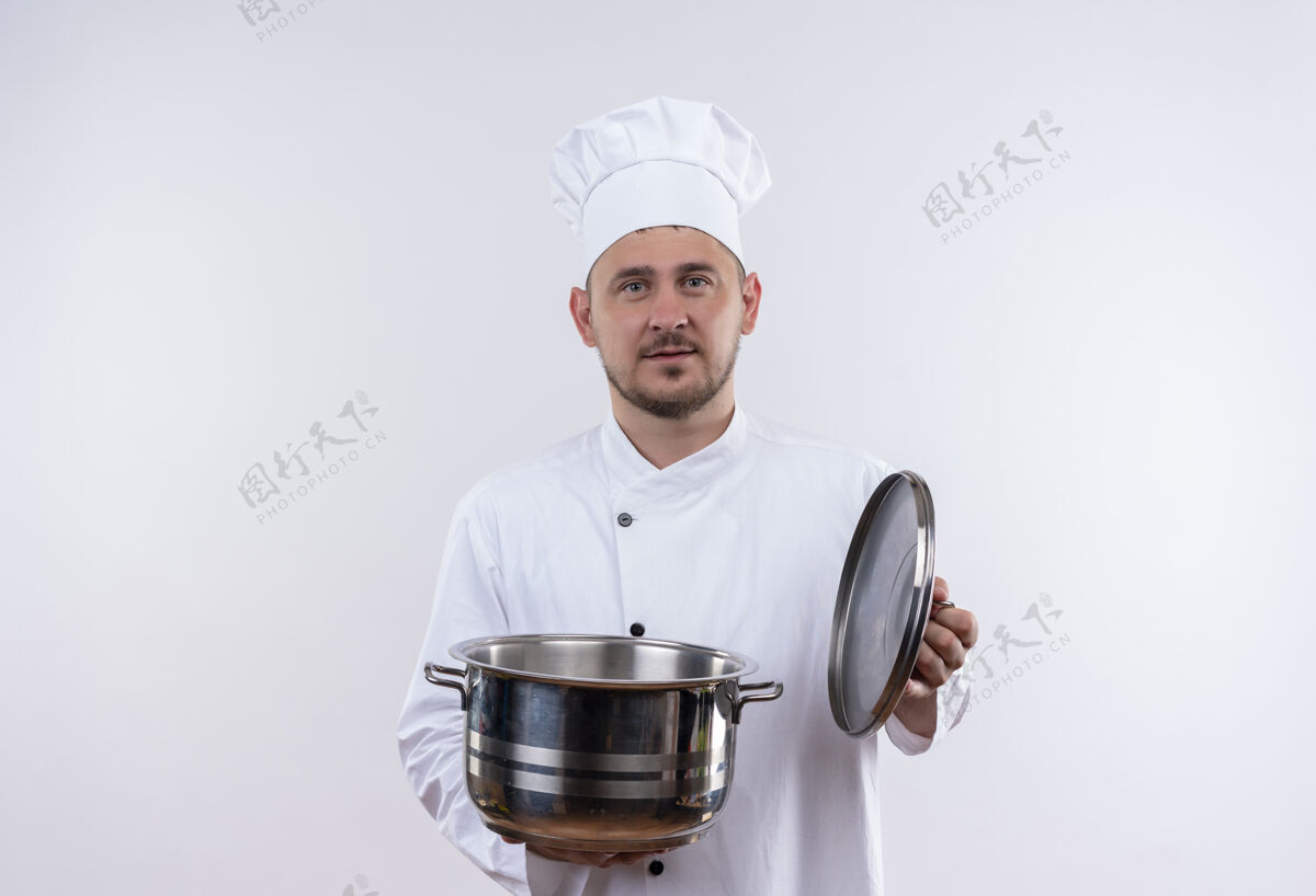 看着年轻帅气的厨师穿着厨师制服拿着锅炉和它的盖子望着与世隔绝的白色空间厨师帅气复制