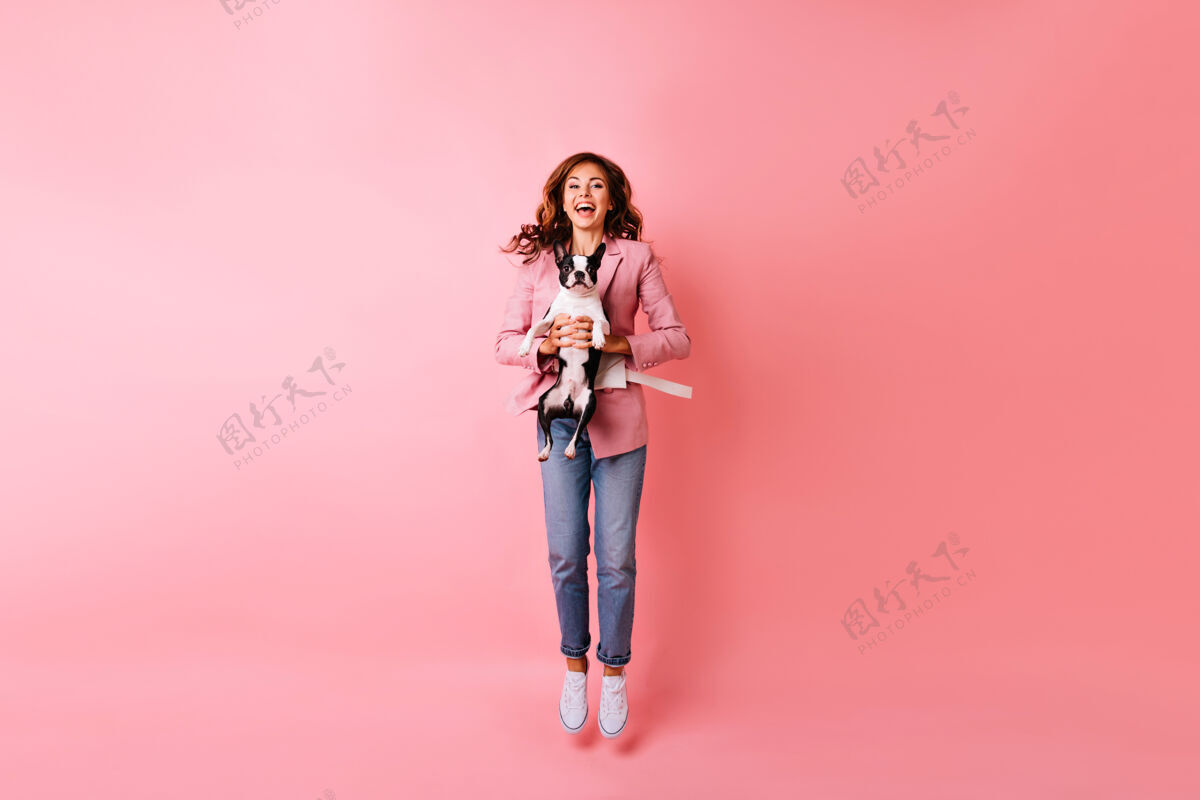 姜狂喜的年轻女子与法国斗牛犬跳跃的全长肖像情绪激动的红发女孩与她的宠物在一起的室内肖像年轻粉色室内