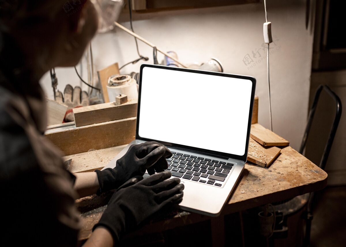 技能高角度的女木匠用笔记本电脑职业劳动者工作