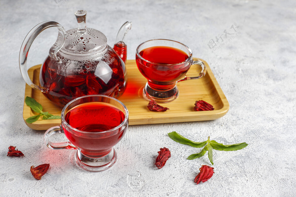 热热木槿茶在一个玻璃杯子和玻璃茶壶草药茶花瓣