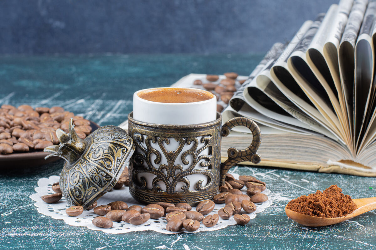 咖啡一杯泡沫咖啡 一盘咖啡豆和一本大理石桌上的书美味咖啡豆泡沫