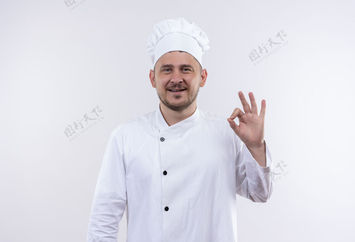 做面带微笑的年轻帅哥厨师身着厨师制服 在空白处做ok标志年轻制服签名