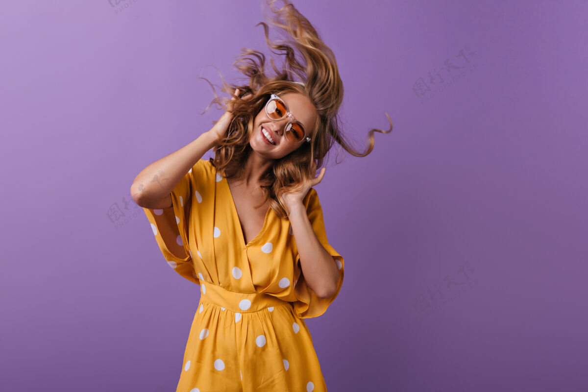 情感戴着太阳镜的快乐白人女孩玩得很开心紫色上跳舞的迷人卷发女人的肖像欧洲女性狂喜