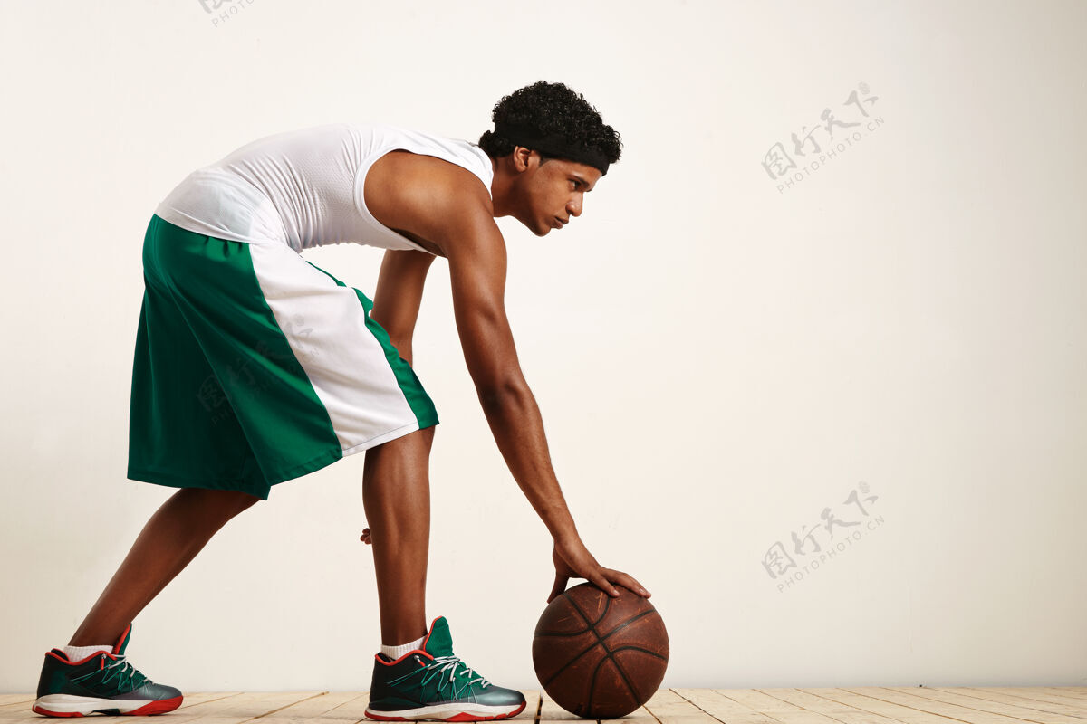 动作一个篮球运动员在白色的背拍照片拿着球在他的身边运动员看现代