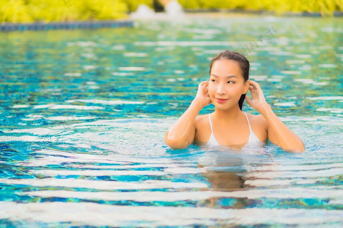 人肖像美丽的亚洲年轻女子放松微笑休闲围绕室外游泳池近海阳光休息游泳
