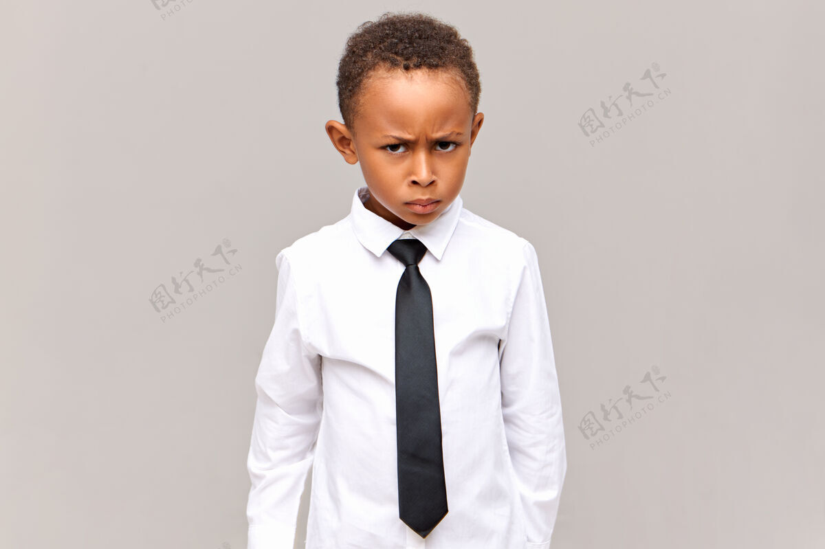 微笑横图：沮丧的黑皮肤学生穿着校服 有愤怒的表情 皱眉 对粗鲁的同学欺负生气 准备为自己辩护非洲男孩悲伤