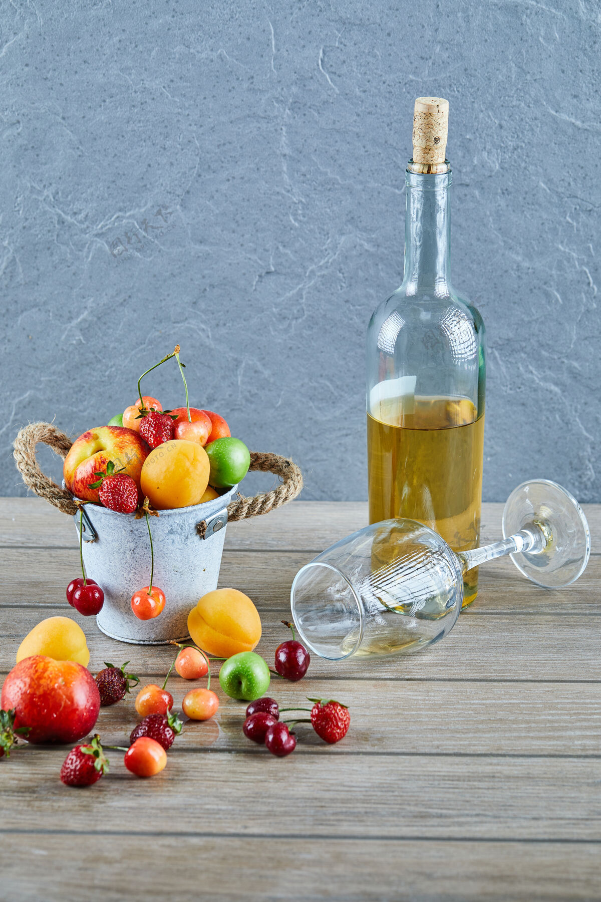 草莓木桌上有一桶夏天的新鲜水果 一瓶白葡萄酒和空杯子酸浆果桌子