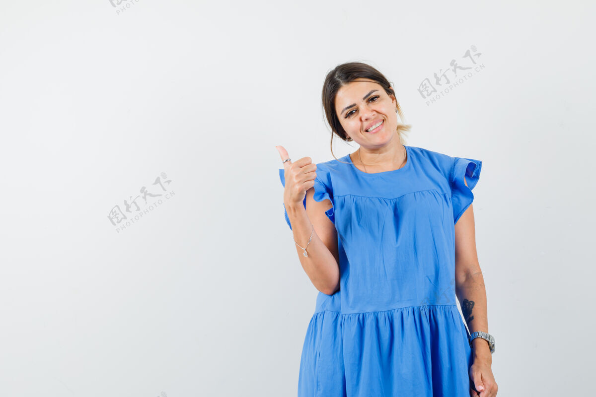 时尚一个穿着蓝色衣服 露出大拇指 看上去很快乐的年轻女人休闲肖像快乐