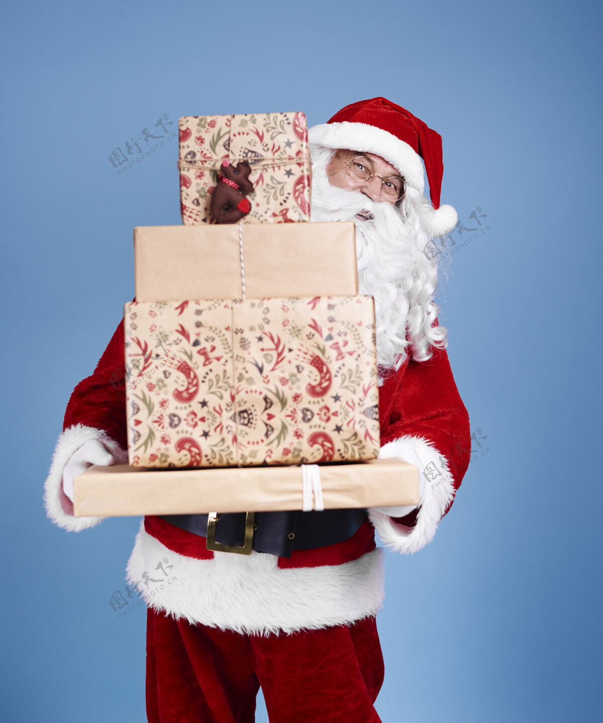 服装圣诞老人拿着一堆圣诞礼物的画像携带欢快工作