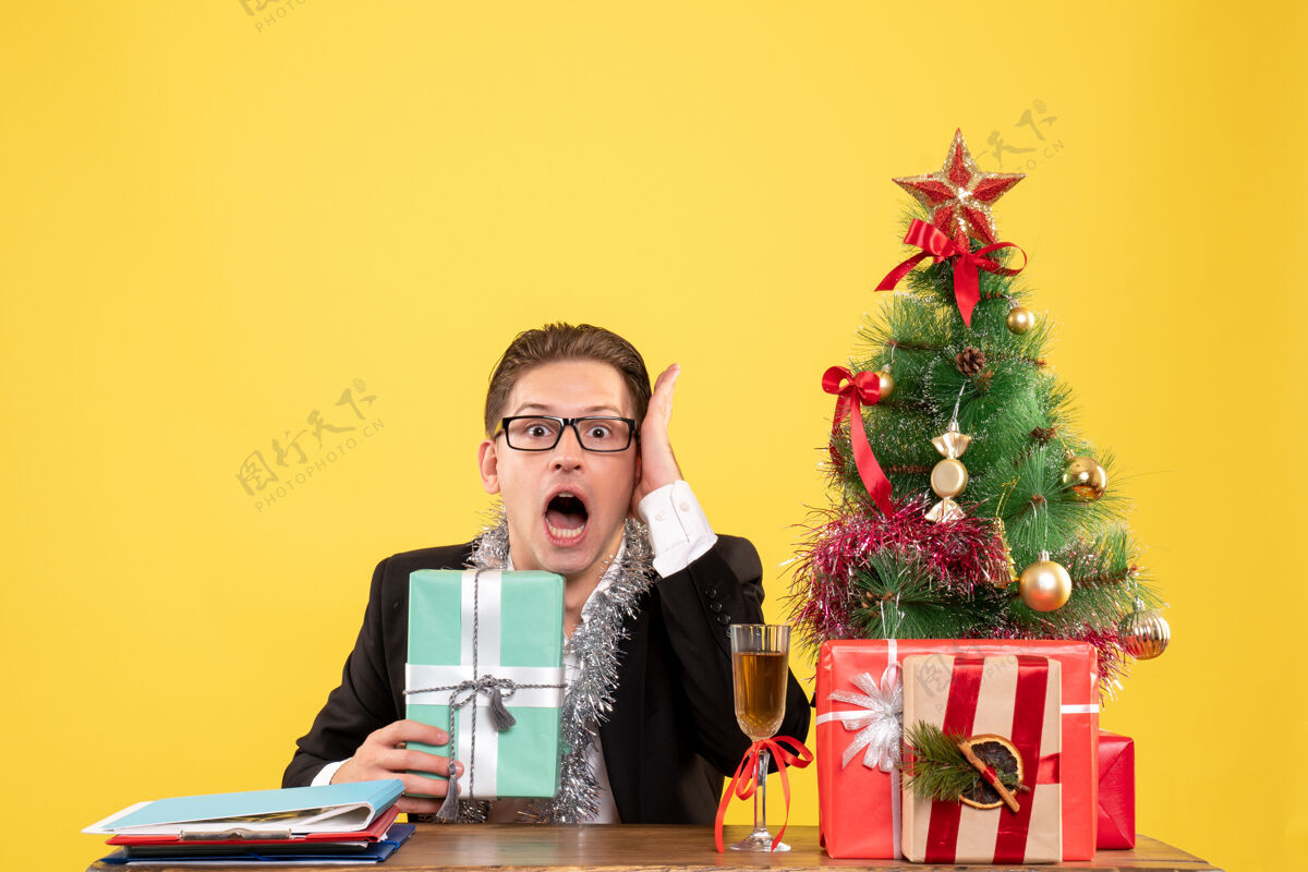 年正面图：男工人拿着圣诞礼物坐着工人电脑礼物