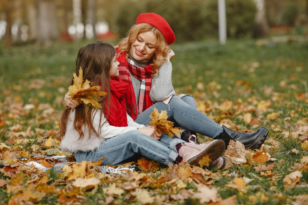 秋天时髦的母亲带着女儿黄色的秋天戴着红领巾的女人休闲衣服卷发