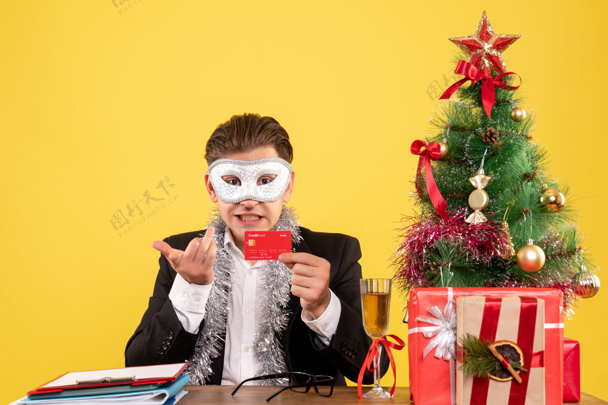 圣诞节正面图戴派对面具手持银行卡的男工人艺人工人音乐家