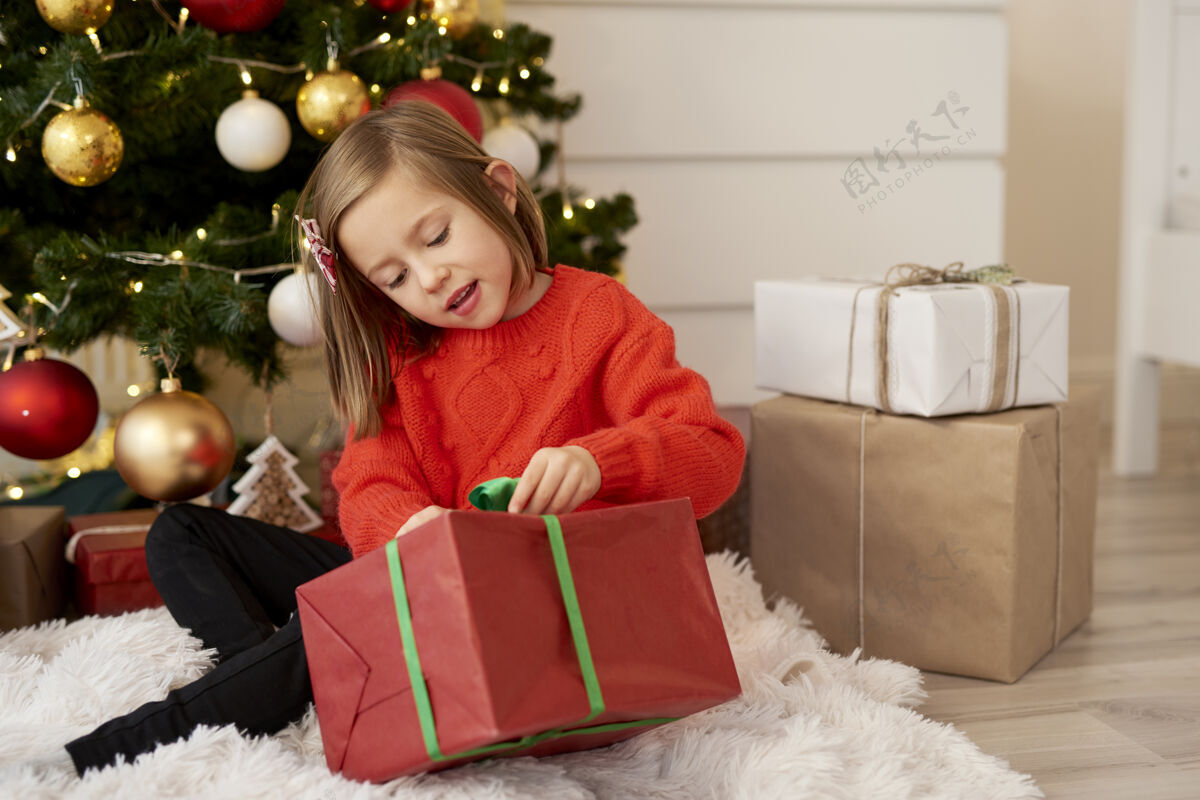 圣诞装饰有圣诞礼物的快乐女孩礼物前面的看法舒适