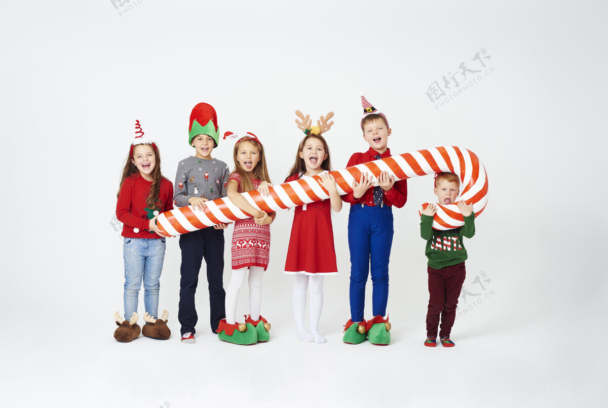 事件快乐的孩子们拿着巨大的糖果棒笑童年圣诞节