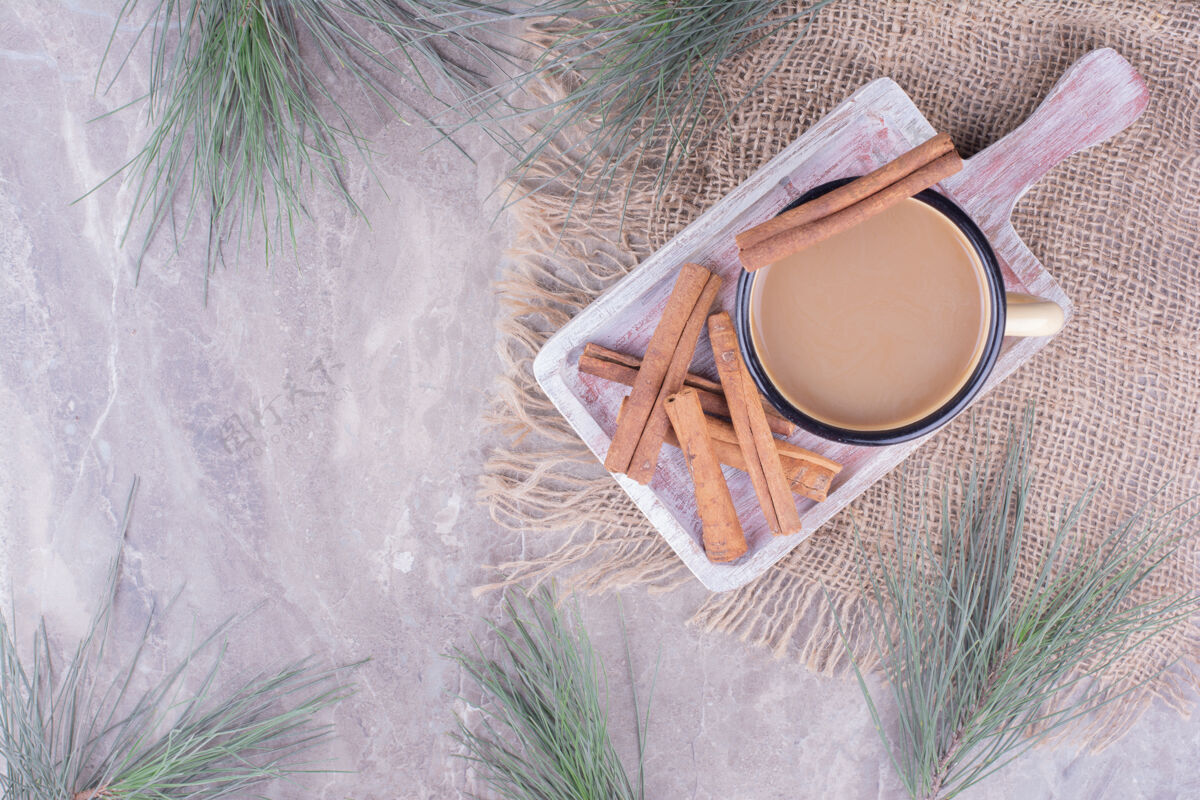 产品一杯咖啡加肉桂棒放在乡村木板上卡布奇诺热异国情调