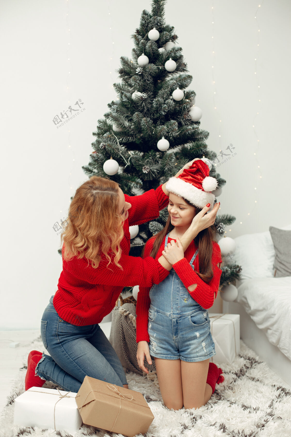花环人们在为圣诞节做准备母亲在和女儿玩耍一家人在节日的房间里休息孩子穿着红色毛衣节日亮光小
