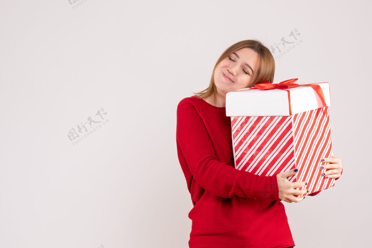 盒子正面图年轻女性手拿礼物盒站着地板节日漂亮