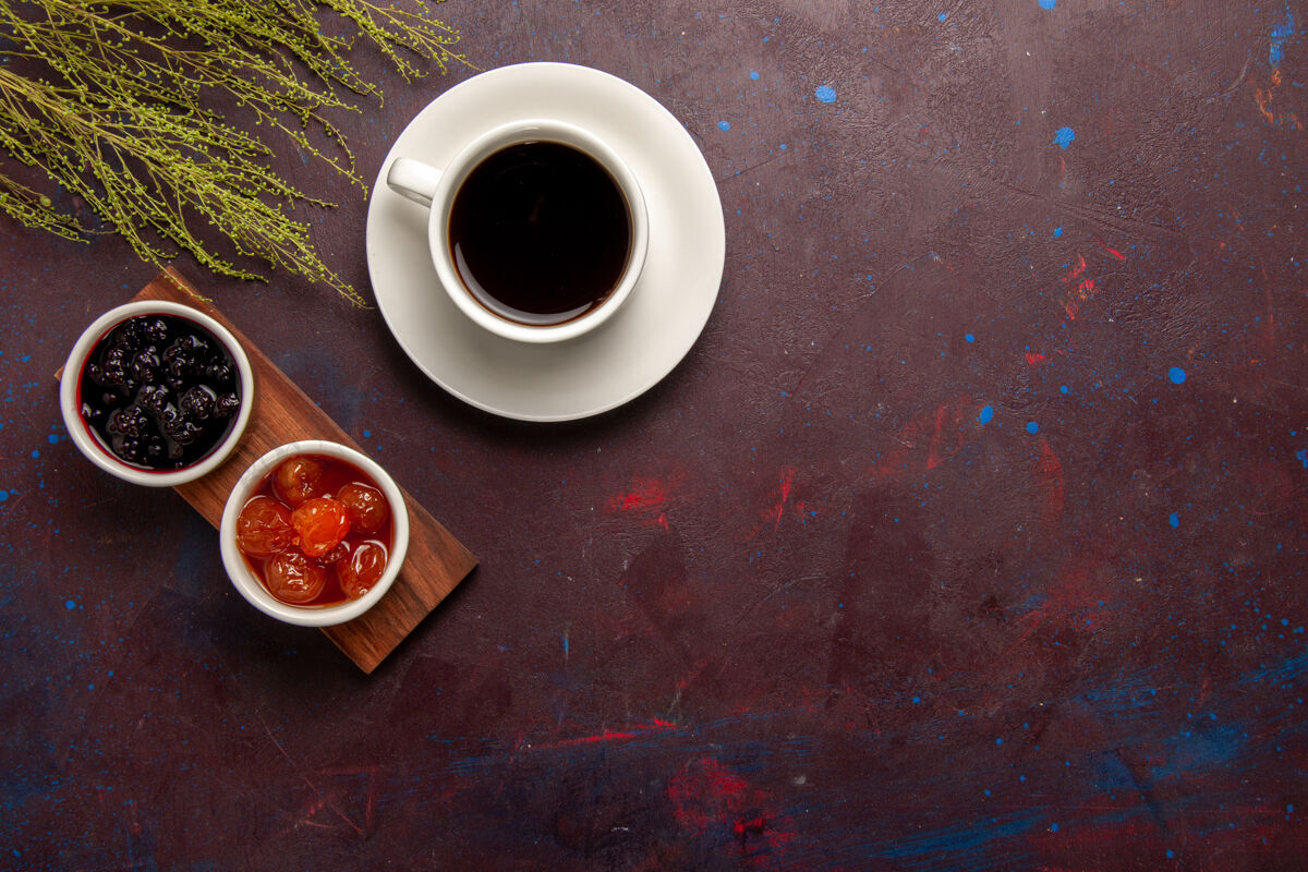 果酱顶视图咖啡杯上不同果酱的深色办公桌果酱果酱果酱甜茶不同的茶碟