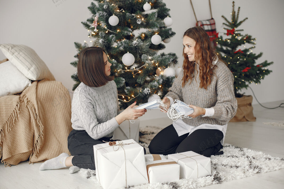 妇女冠状病毒和圣诞节概念家里的女人穿灰色毛衣的女人年轻节日季节