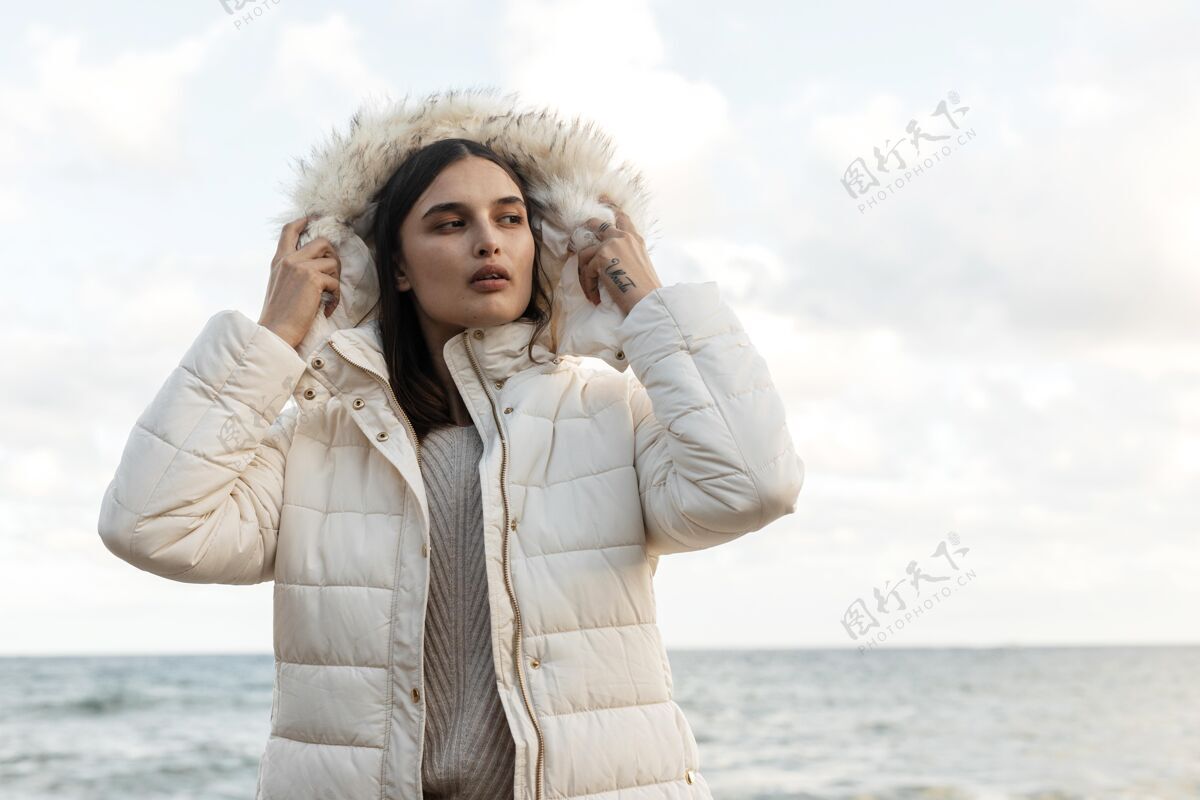 冬天夹克穿着冬衣的海滩美女的正面图公路旅行旅行冒险