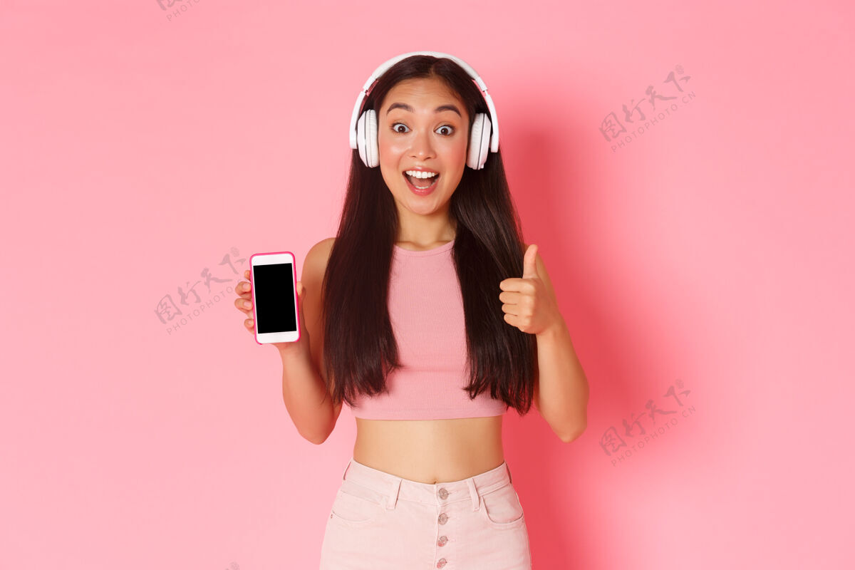 展示屏幕一个戴着耳机听音乐的富有表情的年轻女子歌手日语女性